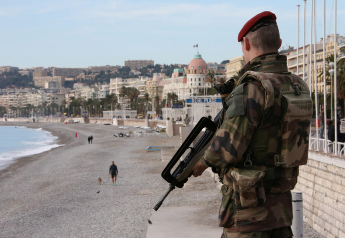 Ein Soldat mit Sturmgewehr patrouilliert am Strand von Nizza