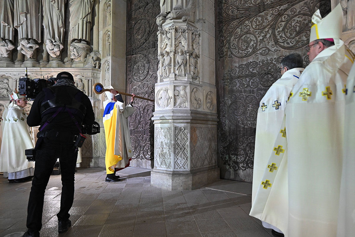 Erzbischof Laurent Ulrich schlägt mit dem Krummstab dreimal gegen das Portal von Notre-Dame, um die Kirche nach der Restaurierung wiederzueröffnen (Foto: IMAGO/Eliot Blondet/Pool/Bestimage)